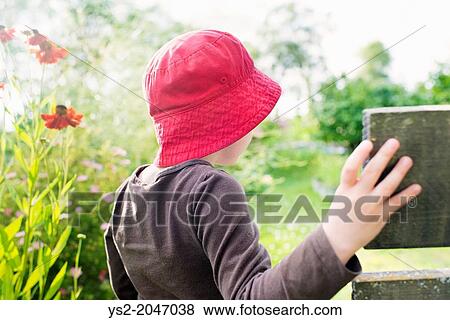 Lifestyle moment with young girl watching a garden filled with flowers and green plants. View Large Photo Image Stock Photo - Lifestyle moment with young girl watching a garden filled with flowers and green plants.. Fotosearch