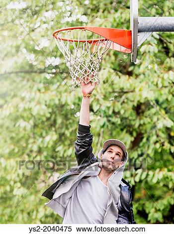 Lifestyle portrait of young man in leather jacket jumping and reching for a basketball hoop. View Large Photo Image Stock Photography - Lifestyle portrait of young man in leather jacket jumping and reching for a basketball hoop.. Fotosearch