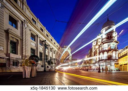 Stock Image - Light trails of a streetcar on Constitution Avenue, Seville, Spain. Fotosearch
