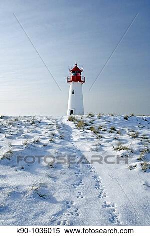 Lighthouse List West, seen from a low perspective, on snow covered dunes showing tracks of a rabbit leading to the lighthouse, with a bright blue sky at a sunny day, Sylt, Northfrisian Islands, Schleswig-Holstein, Northern Germany, Europe View Large Photo Image Stock Photography - Lighthouse List West, seen from a low perspective, on snow covered dunes showing tracks of a rabbit leading to the lighthouse, with a bright blue sky at a sunny day, Sylt, Northfrisian Islands, Schleswig-Holstein, Northern Germany, Europe. Fotosearch