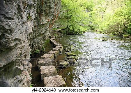 Stock Image - Limestone stepping stones on the River Wye at Chee Dale, Derbyshire Peak District National Park, England, UK.. Fotosearch
