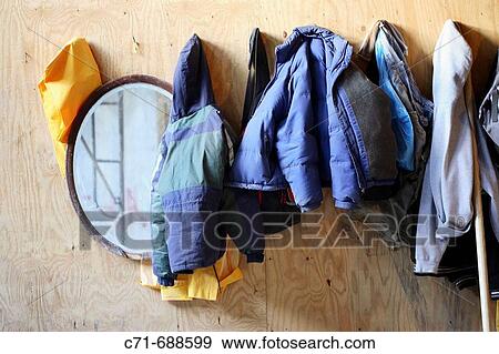Line of winter coats on plywood construction wall View Large Photo Image Stock Photo - Line of winter coats on plywood construction wall. Fotosearch
