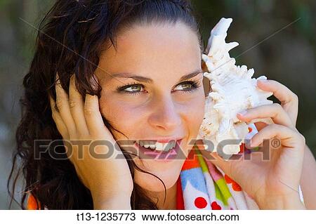 Listen the sea shell sound View Large Photo Image Stock Image - Listen the sea shell sound. Fotosearch