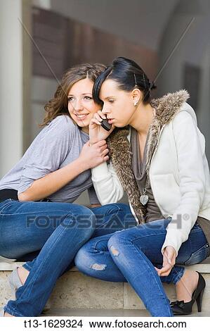 Listening for her friend's cellular talk View Large Photo Image Picture - Listening for her friend's cellular talk. Fotosearch