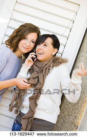 Stock Photo - Listening for her friend's cellular talk. Fotosearch