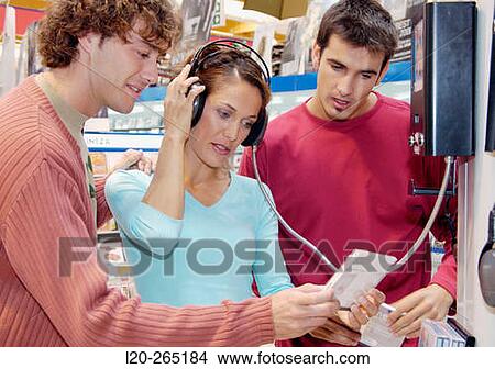 Picture - Listening to a CD at shopping center. Fotosearch