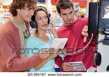 Listening to a CD at shopping center View Large Photo Image Stock Photo - Listening to a CD at shopping center. Fotosearch
