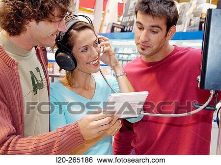 Listening to a CD at shopping center View Large Photo Image Stock Photograph - Listening to a CD at shopping center. Fotosearch