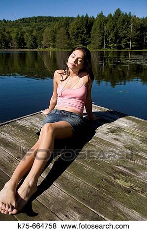 listening to music lying on dock View Large Photo Image Stock Photo - listening to music lying on dock. Fotosearch