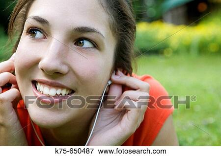 Stock Photo - listening to music on mp3 player. Fotosearch