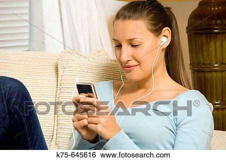 Listening to music on mp3 player View Large Photo Image Stock Photograph - Listening to music on mp3 player. Fotosearch