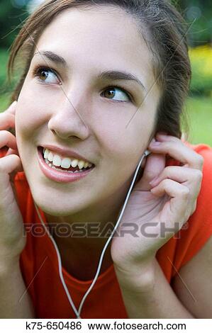 Stock Photograph - Listening to music on mp3 player. Fotosearch