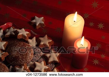 Stock Photograph - Lit candles and lots of christmas cookies. Fotosearch