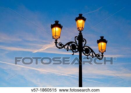 Lit up street light at dawn. The Retiro park, Madrid, Spain. View Large Photo Image Stock Photography - Lit up street light at dawn. The Retiro park, Madrid, Spain.. Fotosearch