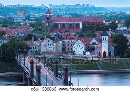 Stock Image - Lithuania, Central Lithuania, Kaunas, elevated view of Sts Peter and Paul Cathedral and Aleksoto tiltas bridge, dusk. Fotosearch