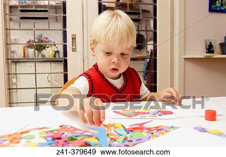 Stock Photo - Little boy doing handicraft. Fotosearch