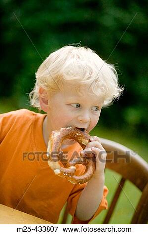 Little boy eating pretzel View Large Photo Image Stock Photo - Little boy eating pretzel. Fotosearch