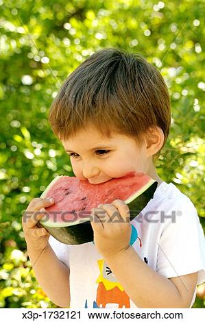 Stock Image - Little boy eating watermelon. Fotosearch