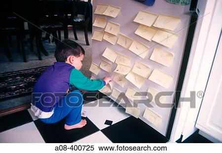 Stock Photography - Little boy has fun with stick on notes. USA.. Fotosearch