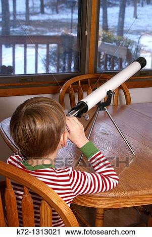 Little boy inside looking outside in winter through a telescope View Large Photo Image Stock Image - Little boy inside looking outside in winter through a telescope. Fotosearch