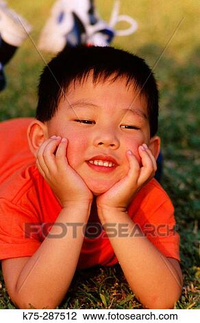 little boy lying on the lawn View Large Photo Image Stock Image - little boy lying on the lawn. Fotosearch