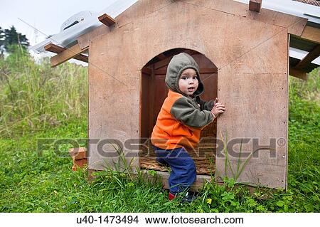 Little boy playing in dog house View Large Photo Image Picture - Little boy playing in dog house. Fotosearch