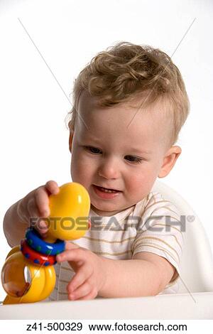 Little boy playing with a plastic rattle doll View Large Photo Image Stock Photo - Little boy playing with a plastic rattle doll. Fotosearch