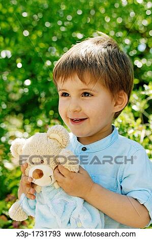 Little boy playing with a teddy bear View Large Photo Image Stock Image - Little boy playing with a teddy bear. Fotosearch