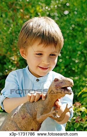Little boy playing with a Tirannosaurus rex View Large Photo Image Stock Photograph - Little boy playing with a Tirannosaurus rex. Fotosearch