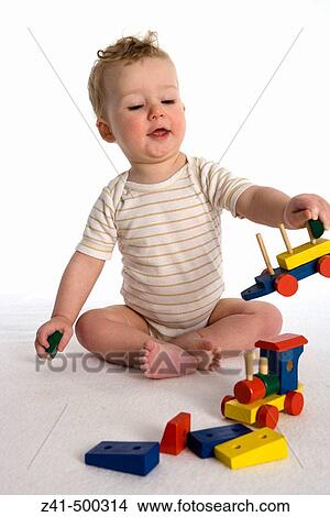 Picture - Little boy playing with a wooden train. Fotosearch