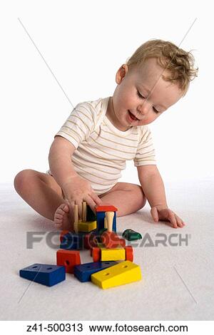 Little boy playing with a wooden train View Large Photo Image Stock Image - Little boy playing with a wooden train. Fotosearch