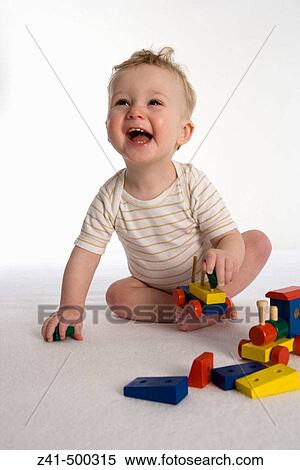 Stock Photography - Little boy playing with a wooden train. Fotosearch