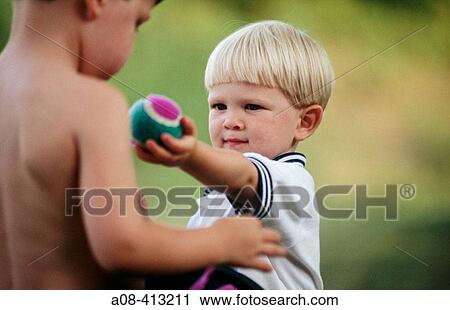 Stock Image - Little boy shares his ball with friend. Pennsylvania. USA.. Fotosearch
