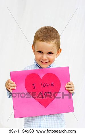 Stock Image - little boy showing a loving poster. Fotosearch