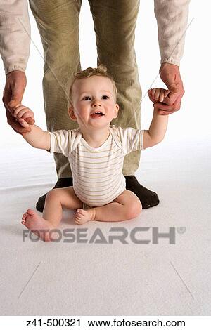 Little boy sitting against his father's legs View Large Photo Image Stock Image - Little boy sitting against his father's legs. Fotosearch