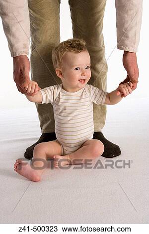 Little boy sitting against his father's legs View Large Photo Image Stock Image - Little boy sitting against his father's legs. Fotosearch
