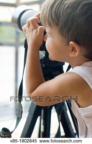 Stock Photography - Little boy taking pictures with a camera.. Fotosearch