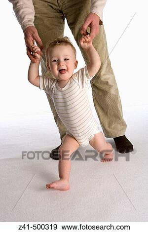 Stock Photo - Little boy walking with father's hands. Fotosearch