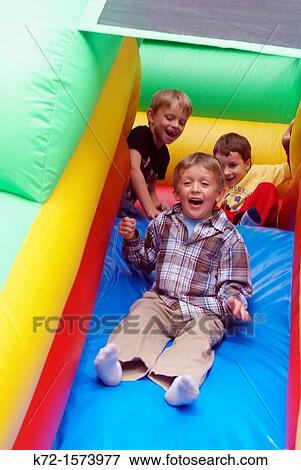 Little boys excited on slide on an inflatable ride View Large Photo Image Stock Photo - Little boys excited on slide on an inflatable ride. Fotosearch
