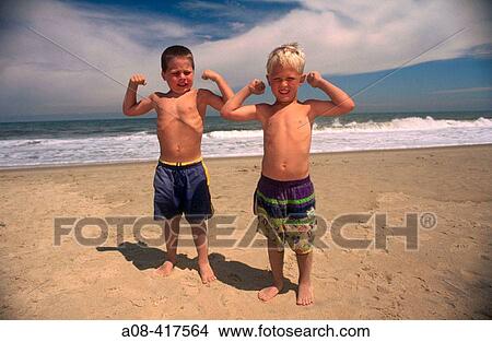 Little boys flex their bicep muscles at the beach. Delaware, USA View Large Photo Image Picture - Little boys flex their bicep muscles at the beach. Delaware, USA. Fotosearch