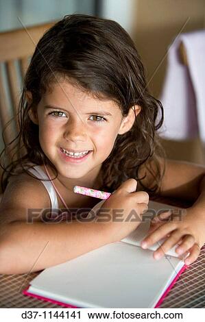 Little caucasian girl writing on a notebook smiling View Large Photo Image Stock Image - Little caucasian girl writing on a notebook smiling. Fotosearch
