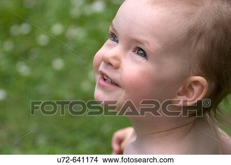 Picture - Little Child in Garden Looking Upwards. Fotosearch