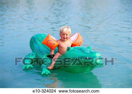 Little child on inflatable crocodile View Large Photo Image Picture - Little child on inflatable crocodile. Fotosearch