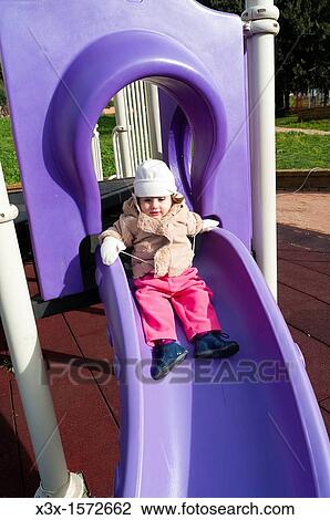 Little child playing on a playground slide View Large Photo Image Stock Image - Little child playing on a playground slide. Fotosearch