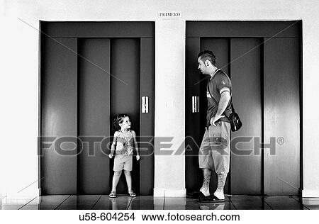 Picture - Little girl and man in front of elevator.. Fotosearch