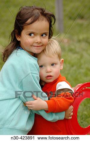 Little girl and toddler boy hugging View Large Photo Image Stock Image - Little girl and toddler boy hugging. Fotosearch