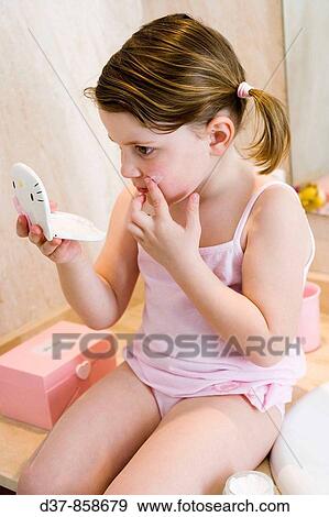 Little girl applying cream on her face View Large Photo Image Stock Photo - Little girl applying cream on her face. Fotosearch