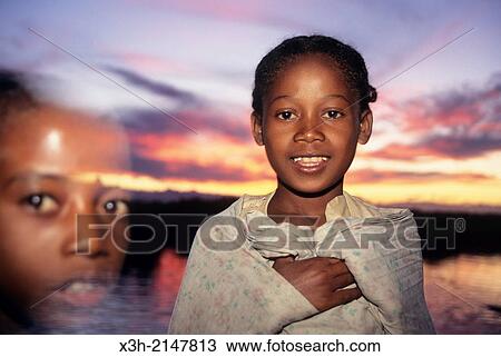Stock Image - little girl at the seaside at sunset, Tulear, Madagascar, Indian Ocean, Southeast Africa.. Fotosearch