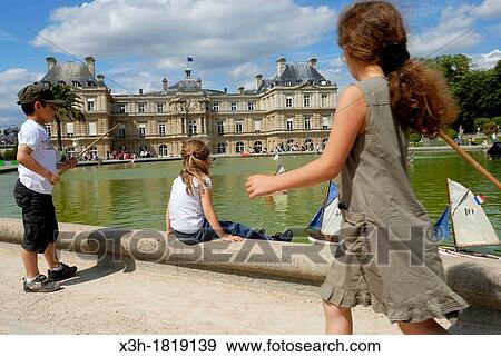 Stock Photo - little girl by the pool in front of the French Senate Palace, Jardin du Luxembourg, Paris, Ile-de-France region, France, Europe. Fotosearch