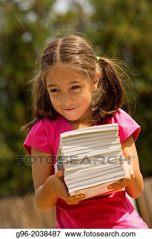Little girl carries a lot of books. View Large Photo Image Stock Photo - Little girl carries a lot of books.. Fotosearch